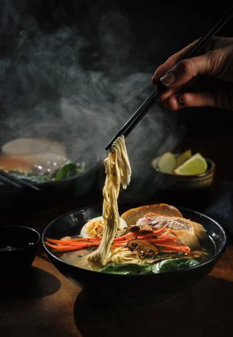 Yemek çubukları ile el ramen çorbası erişte alır. Geleneksel Olarak