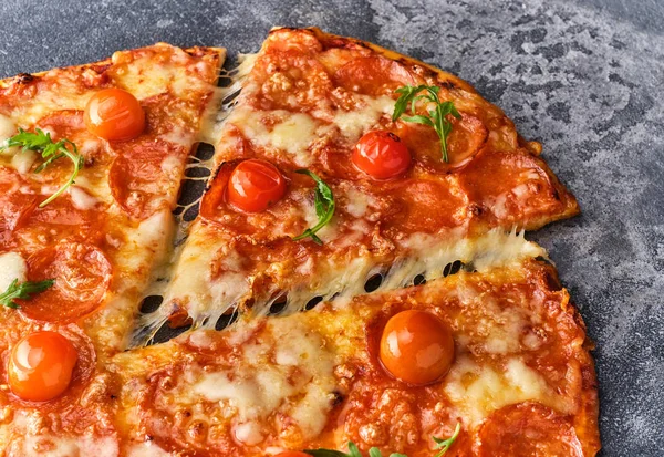 Stukje pepperoni pizza met cherry tomaten. Gesneden smakelijke pepp — Stockfoto