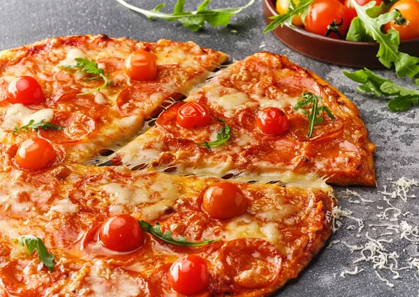 Stukje pepperoni pizza met cherry tomaten. Gesneden smakelijke pepp — Stockfoto