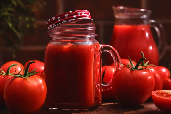 Sabroso jugo de tomate en un frasco de albañil con tomates rojos maduros . — Foto de Stock