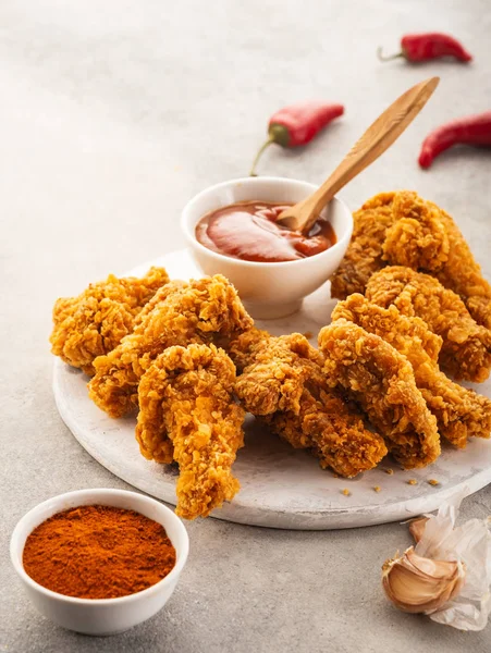 Ailes de poulet épicées panées avec des épices et du ketchup sur la table — Photo