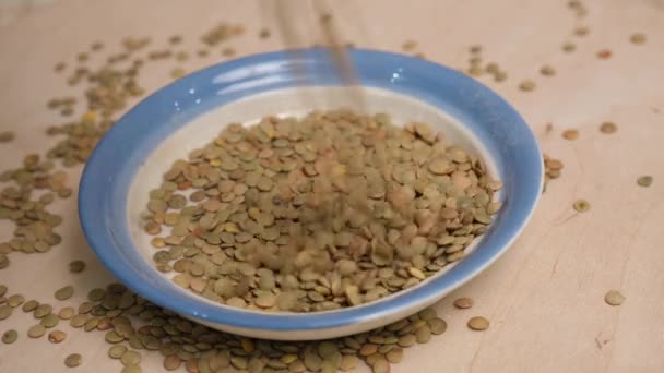 Lentil grains are poured into a bowl. 4k video shot. — Stock Video