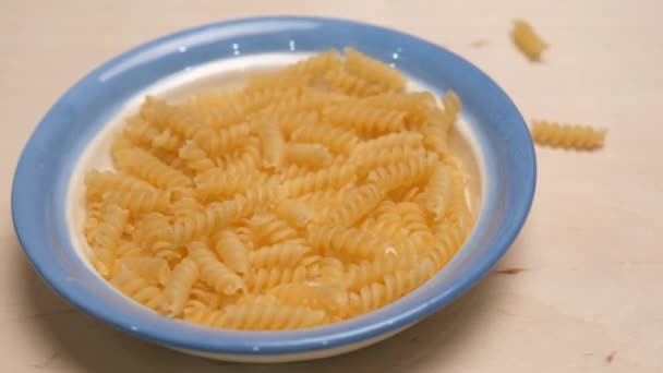 Los granos de pasta se enrollan en una olla de cerámica. Captura de vídeo 4k . — Vídeo de stock
