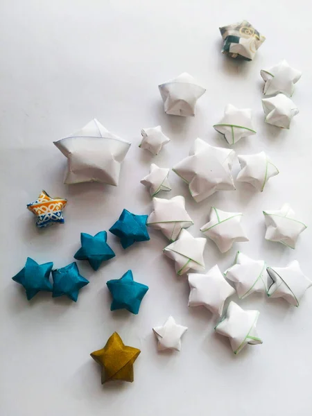 Origami paper colored stars on a white background.