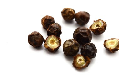 Beyaz arka planda tahta kaşıkta siyah biber..