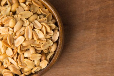 Kavrulmuş fıstık ahşap arka plan üzerinde ahşap kase.