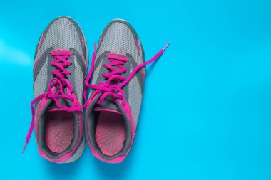 Spor düz pembe ayakkabı boşaltmak metniniz için mavi arka plan üzerine yatırın. Kavram sağlıklı yaşam tarzı ve diyet.