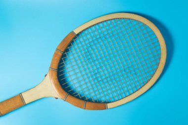 Mavi arka plan üzerinde tenis raketi. Spor donatımı. Düz yatıyordu.