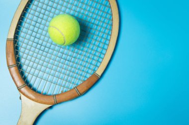 Tenis raket ve top mavi zemin üzerine. Spor donatımı. Düz yatıyordu.