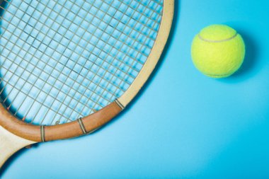 Tenis raket ve top mavi zemin üzerine. Spor donatımı. Düz yatıyordu.