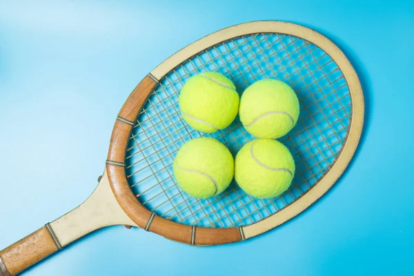 Tennis racket and balls on blue background. Sport equipment. Flat lay.