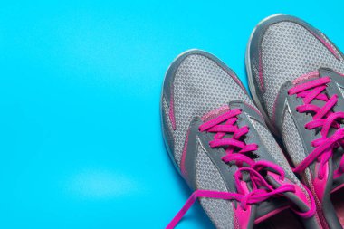 Spor düz pembe ayakkabı boşaltmak metniniz için mavi arka plan üzerine yatırın. Kavram sağlıklı yaşam tarzı ve diyet.