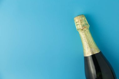 Şampanya şişesi üzerinde mavi arka plan, kutlama kavramı.