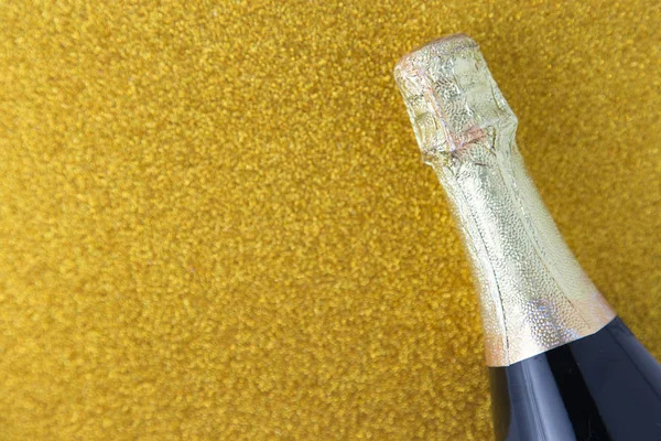 Champagne bottle on gold glitter background, Celebration concept.