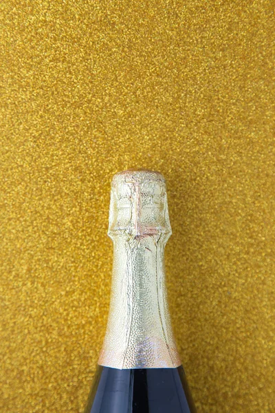 Champagne bottle on gold glitter background, Celebration concept.