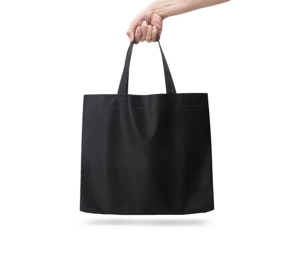 クリッピングパスで白い背景に隔離されたブランクの黒いファブリックキャンバスバッグを手に持ち エココンセプト — ストック写真