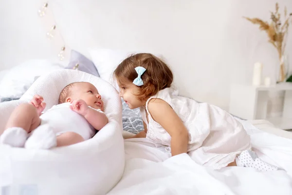 Hermosa Hermanita Años Mira Hermano Recién Nacido Acostado Cama Dormitorio — Foto de Stock