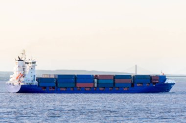 Günbatımında Bristol kanalında kargo gemisi. Arka planda İkinci Severn Geçidi köprüsü..