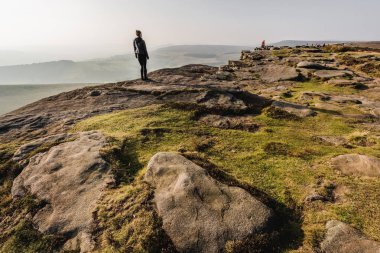 Bir adam uçurumun tepesinde yürür.