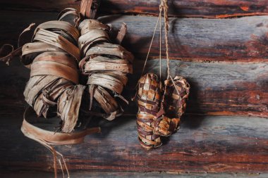 Duvarda kurumuş tahta ayakkabılar var. 