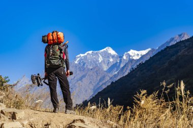 Sırt çantalı bir yürüyüşçü dağlarda yürüyüş yapıyor.