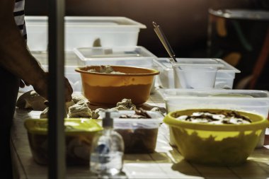 Bir adamın sofrada yemek hazırlarken çekilmiş görüntüsü.