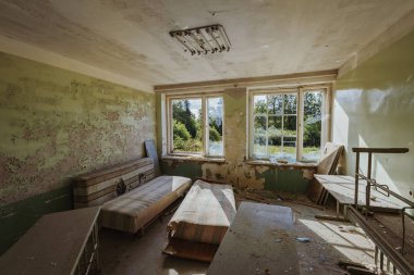 Enkaz ve molozlarla dolu terk edilmiş bir binanın içinde.