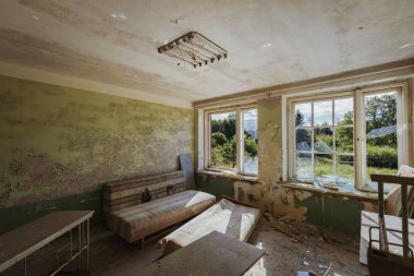 Enkaz ve molozlarla dolu terk edilmiş bir binanın içinde.