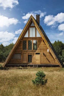 Çam ormanındaki ahşap kulübe. Bahar günbatımı manzarası. Lacupite 'deki botanik bahçesi. Letonya.