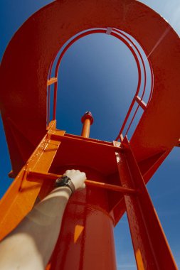 Küçük modern kırmızı deniz feneri direği yenilenmiş beton köstebek mavi gökyüzünde izole.