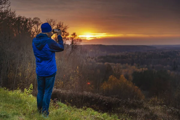 男人在秋天拍摄戏剧性日落的照片 自然美景的概念 — 图库照片