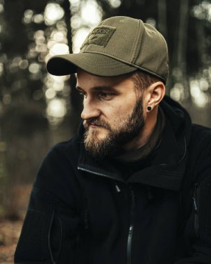 Yeşil şapkalı, siyah kazaklı, sakallı adam. .