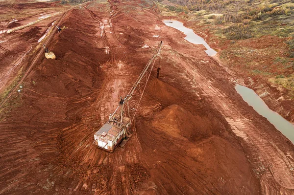 Aerial view of dried out red clay dirt with cracks in clay quarry