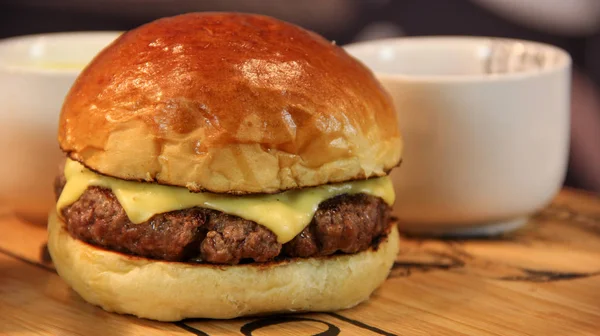 Cheeseburger w brioche bułeczki i sos miski — Zdjęcie stockowe