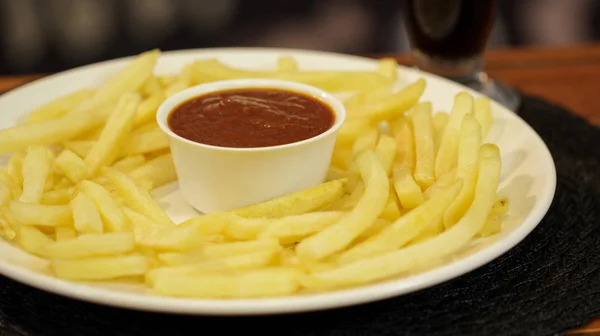 Merkezinde bir ketçap kase ile bir tabak üzerinde gevrek patates kızartması