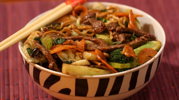 Asya çanak yakisoba üstüne sopalarla bir kase içinde servis