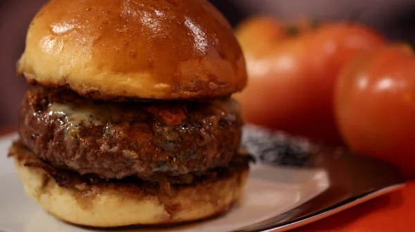 Soczysty duży Hamburger z serem i sosem cebuli i pomidorami — Zdjęcie stockowe
