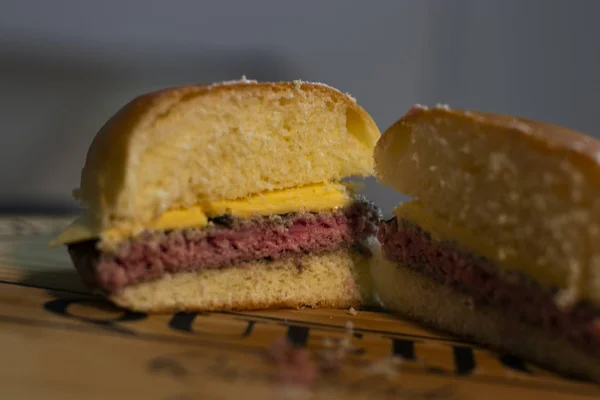 나무 판에 맛있는 반으로 자른 치즈 버거 인테리어 — 스톡 사진