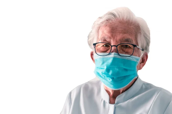 Coronavirus 2019 (COVID-19) enfeksiyonunu önlemek için beyaz elbiseler ve maske takan yaşlı bir Asyalı kadının görüntüsünü ve kesme yolunu ayır.