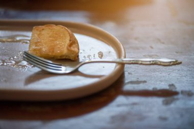 Lezzetli süt ve şekerle kaplı tereyağlı ekmek eski kahve dükkanının son parçasına kadar çatal kullanarak yenir..