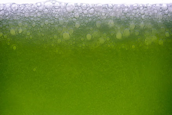 Limon suyu ya da yeşil meyve suyuyla karıştırılmış yakın plan soda köpüklerinin arka planı.