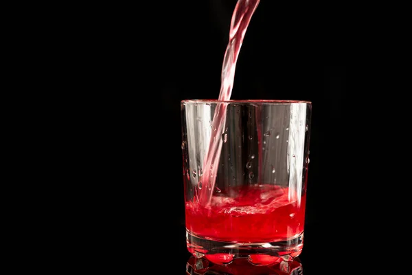 杯子黑色底座上装满红果汁的杯子 — 图库照片