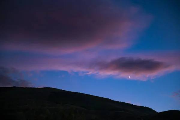 Moon with clouds at sunset