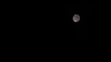 Dolunay kayboluyor ve gece bulutlarda beliriyor.