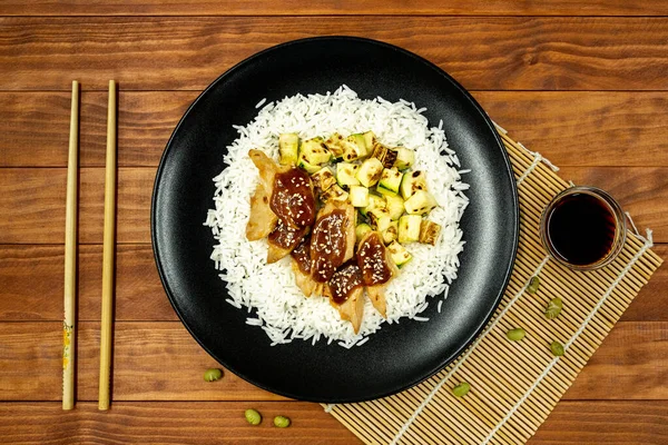 Rice with vegetable protein, teriyaki sauce, and grilled zucchini