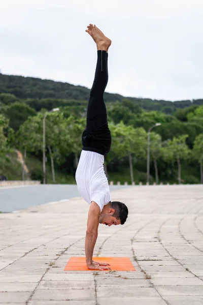 Mladý latinský muž cvičí jógu v parku. Pózování stojanu. — Stock fotografie