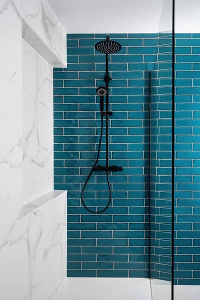 Moderna ducha de azulejos con cabeza de lluvia, ducha de mano y puerta de cristal. Aguamarina oscura y blanco y color en el baño —  Fotos de Stock
