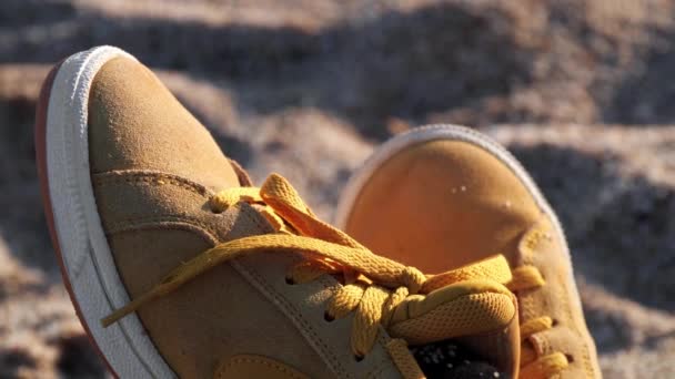 Close up de sapatos amarelos na praia ao pôr do sol — Vídeo de Stock