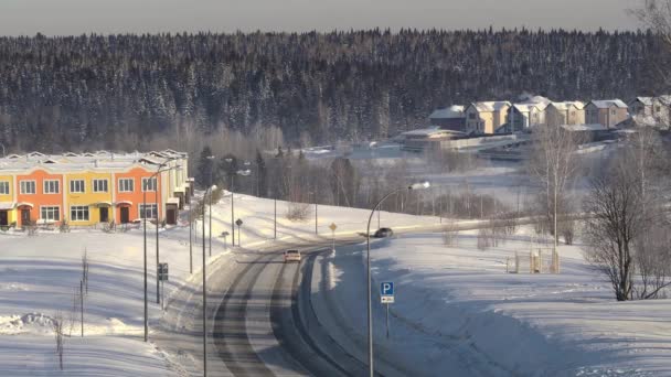 Strada invernale nella campagna russa con auto ed edifici di passaggio, in una giornata di sole con una foresta sullo sfondo — Video Stock
