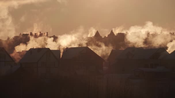 Kouř z komínů na obytných domech ve vesnici během chladné zimy, znečišťující vzduch bílým kouřem — Stock video